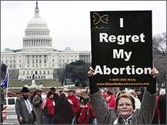 Woman holding 'I Regret my Abortion' sign