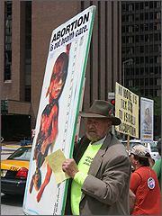 Joe Scheidler holds a baby Malachi sign outside the Hyatt Regency Chicago