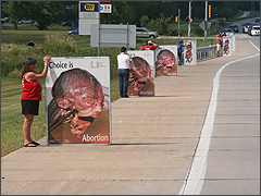 Volunteers hold third trimester abortion signs in Rockford