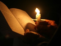 Prayer book lighted by a candle