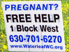 Sidewalk counseling sign points to pregnancy resource center