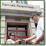 Sidewalk counselor hands literature to a woman outside Planned Parenthood in Chicago