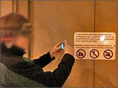 A volunteer takes a picture of the No Picture Taking Sign.